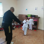 Niño en clase de taekwondo pateando